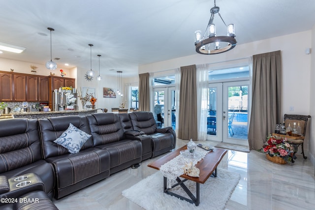 living room with french doors and a notable chandelier