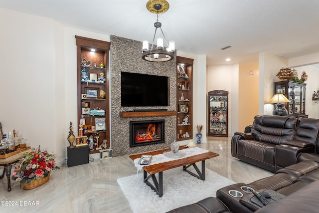 living room featuring built in shelves, a tile fireplace, and an inviting chandelier