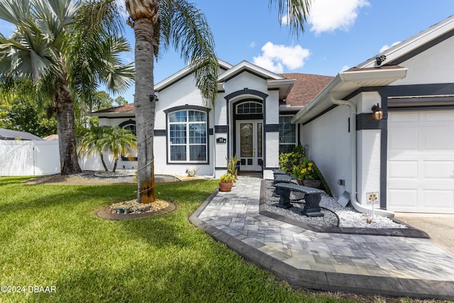 ranch-style house with a garage and a front yard