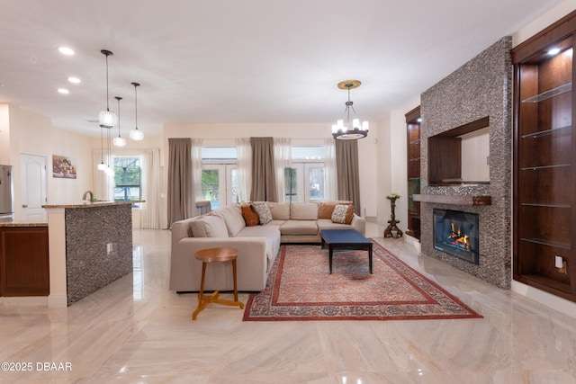 26 Ethel Ln, Palm Coast, FL 32164 - living area featuring a large fireplace, a chandelier, marble finish floor, and recessed lighting
