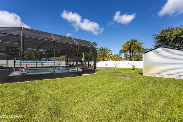 view of yard featuring a lanai, a fenced in pool, and a storage unit