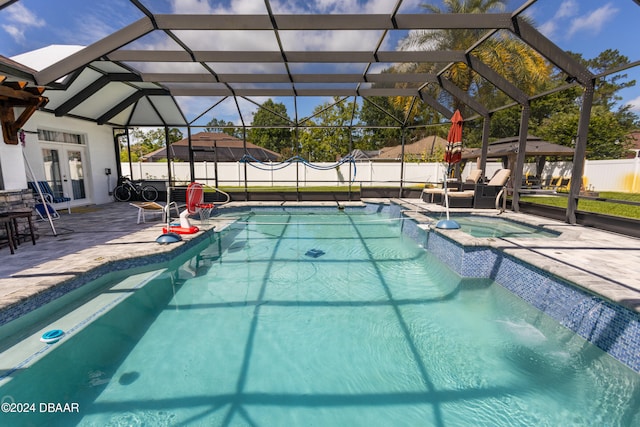 view of swimming pool with an in ground hot tub, french doors, a patio, and glass enclosure