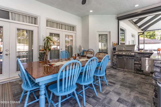 dining area featuring a textured ceiling, french doors, and lofted ceiling