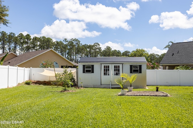 rear view of house featuring a yard and an outbuilding