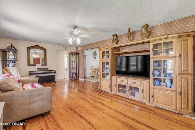 327 Due E St, New Smyrna Beach, FL 32169 - living area featuring ceiling fan, light wood finished floors, and brick wall
