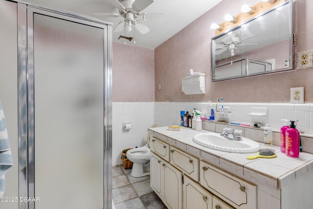 327 Due E St, New Smyrna Beach, FL 32169 - full bath with a ceiling fan, vanity, a shower stall, toilet, and tile patterned floors