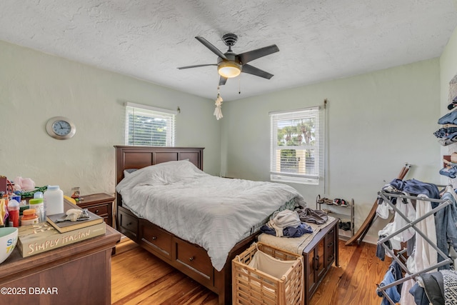 327 Due E St, New Smyrna Beach, FL 32169 - bedroom with light wood-type flooring, ceiling fan, and a textured ceiling