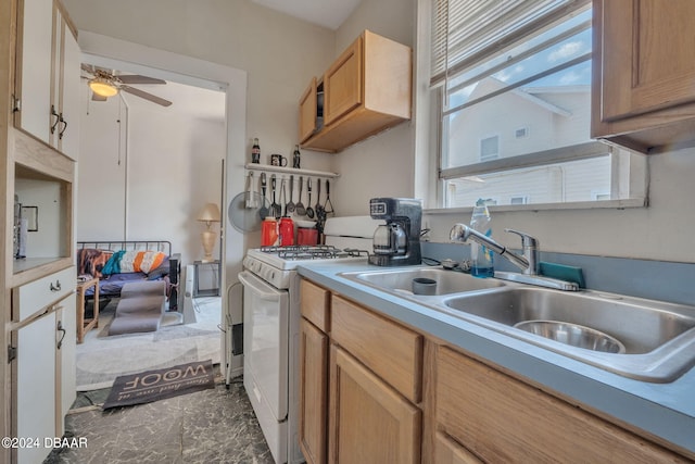 kitchen with white range with gas stovetop, sink, and ceiling fan