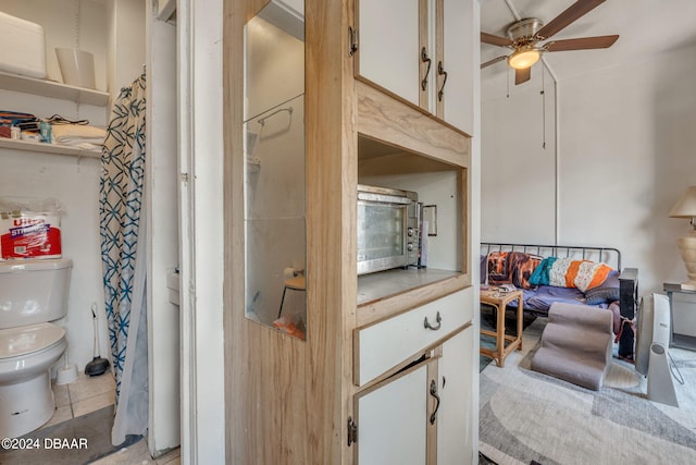 bathroom featuring ceiling fan, tile patterned floors, and toilet