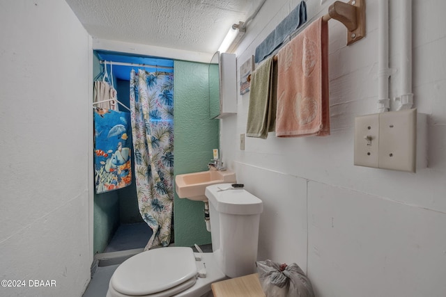 bathroom featuring toilet, sink, a textured ceiling, and walk in shower