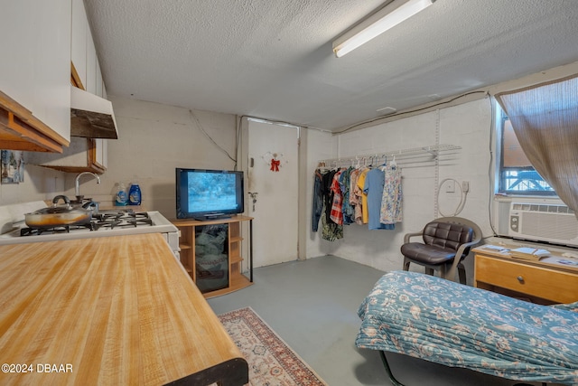 bedroom with a textured ceiling, cooling unit, and concrete floors