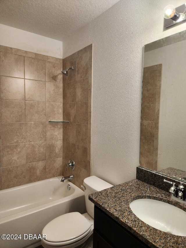 full bathroom with vanity, a textured ceiling, toilet, and tiled shower / bath