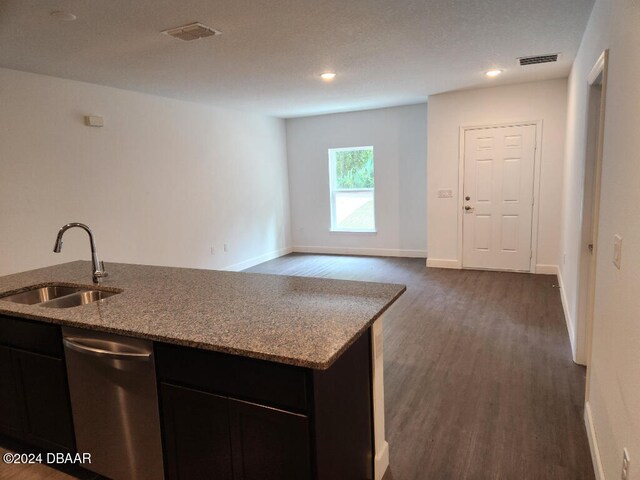 kitchen with stainless steel dishwasher, sink, light stone counters, and dark hardwood / wood-style floors