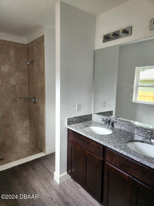 bathroom featuring vanity, hardwood / wood-style flooring, and a tile shower