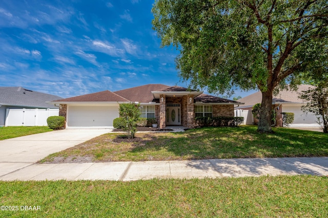 ranch-style house with a front lawn, fence, brick siding, concrete driveway, and an attached garage