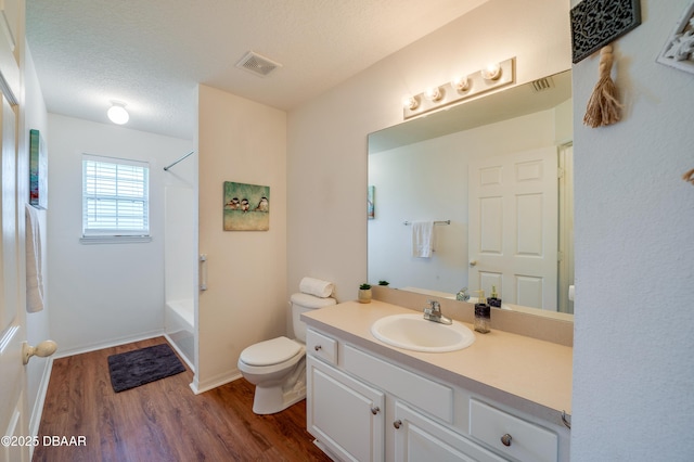 full bathroom featuring vanity, toilet, wood finished floors, shower / bathing tub combination, and visible vents