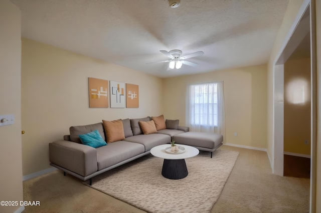living area featuring carpet floors, ceiling fan, and baseboards