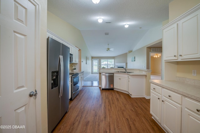 kitchen featuring ceiling fan, dark wood finished floors, open floor plan, stainless steel appliances, and white cabinetry