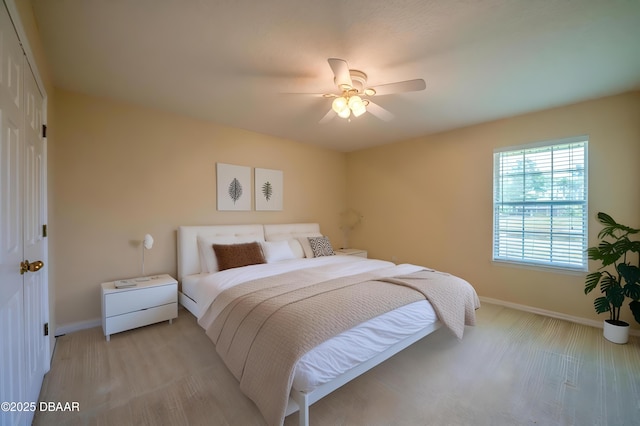 bedroom with a closet, baseboards, and a ceiling fan