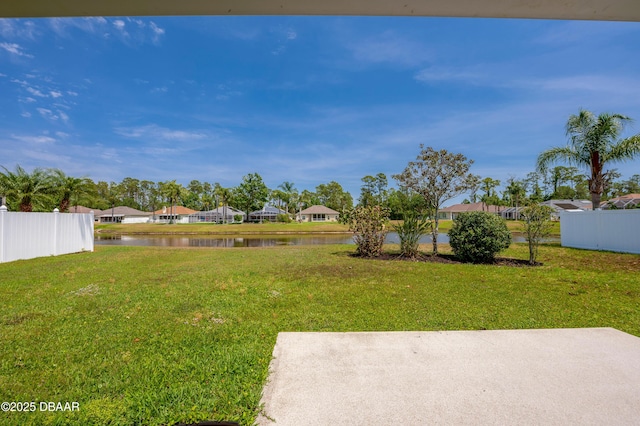 view of yard with fence, a patio, a water view, and a residential view
