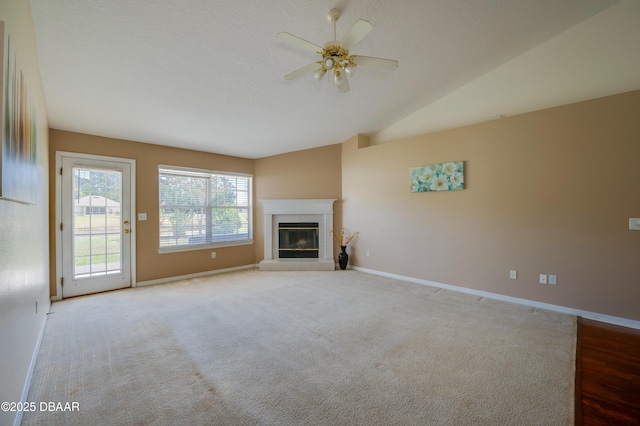 unfurnished living room with a glass covered fireplace, baseboards, a ceiling fan, and carpet flooring