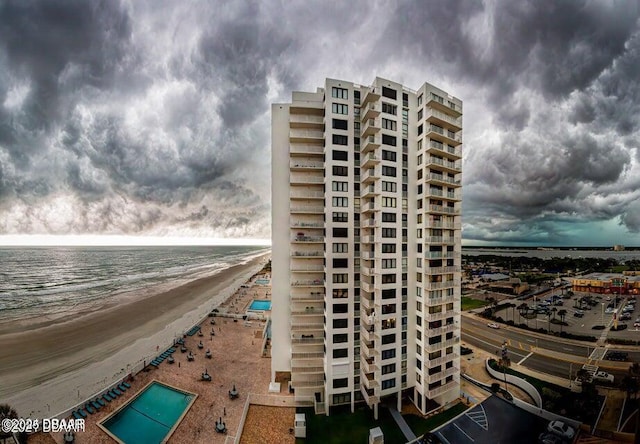 view of building exterior with a water view and a beach view