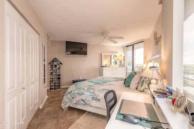 bedroom with ceiling fan, a closet, and floor to ceiling windows