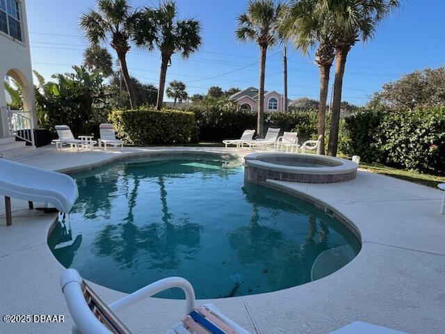 610 S Atlantic Ave, New Smyrna Beach, FL 32169 - view of pool with a water slide, a patio area, and a pool with connected hot tub