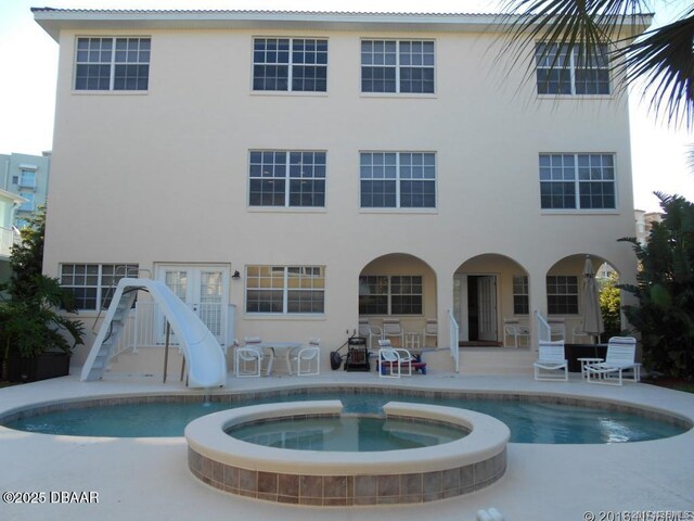 610 S Atlantic Ave, New Smyrna Beach, FL 32169 - view of pool with a patio area, a water slide, and a pool with connected hot tub