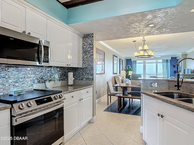 2055 S Atlantic Ave S Unit 1410, Daytona Beach, FL 32118 - kitchen with appliances with stainless steel finishes, crown molding, a chandelier, light tile patterned floors, and backsplash