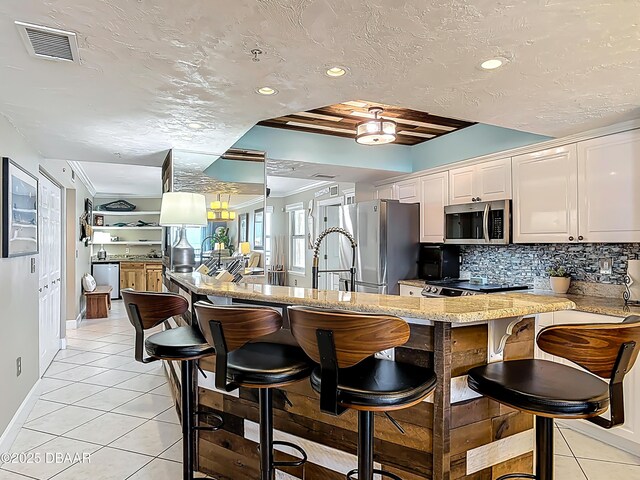 2055 S Atlantic Ave S Unit 1410, Daytona Beach, FL 32118 - kitchen with appliances with stainless steel finishes, light tile patterned floors, a peninsula, backsplash, and recessed lighting