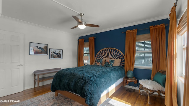 bedroom featuring hardwood / wood-style floors, ceiling fan, and ornamental molding