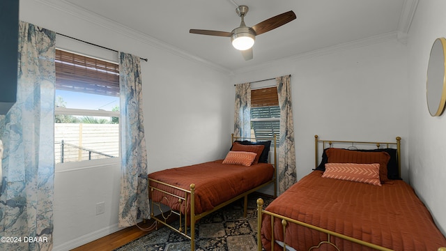 bedroom with hardwood / wood-style flooring, ceiling fan, and ornamental molding