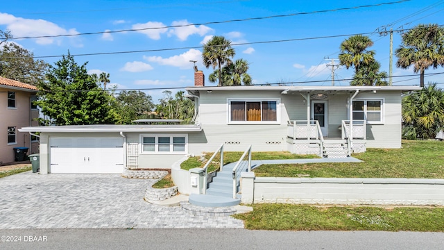 131 Mitchell Pl, Daytona Beach, FL 32118 - view of front of home with a chimney, an attached garage, decorative driveway, and a front lawn