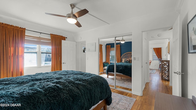 bedroom with a closet, ceiling fan, light hardwood / wood-style flooring, and ornamental molding