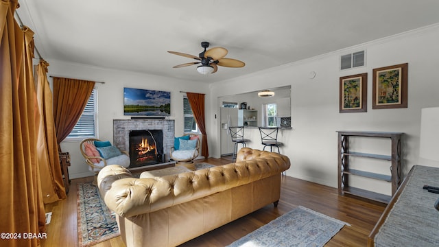 living room with dark hardwood / wood-style floors, ceiling fan, and ornamental molding