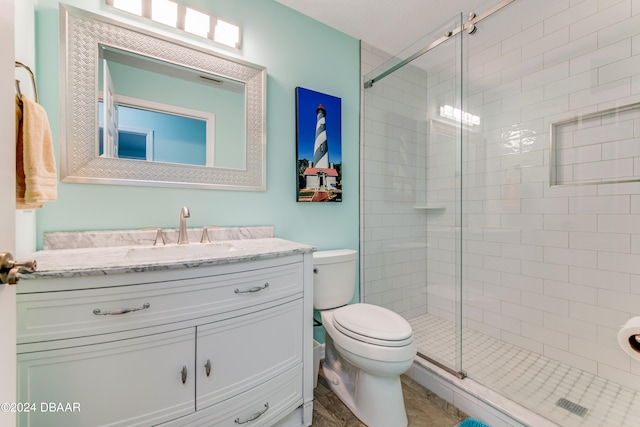 bathroom featuring walk in shower, vanity, and toilet