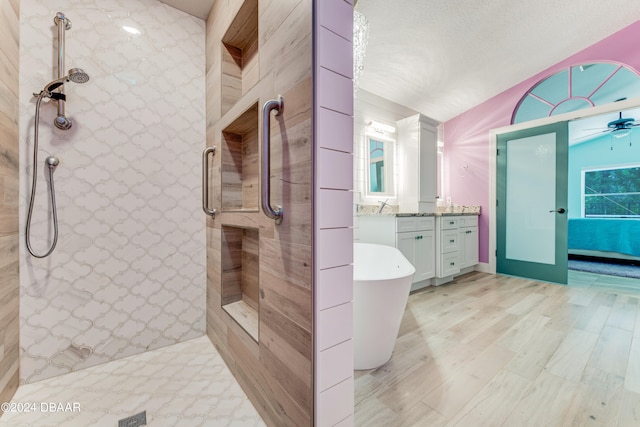 bathroom with vanity, shower with separate bathtub, hardwood / wood-style floors, and a textured ceiling