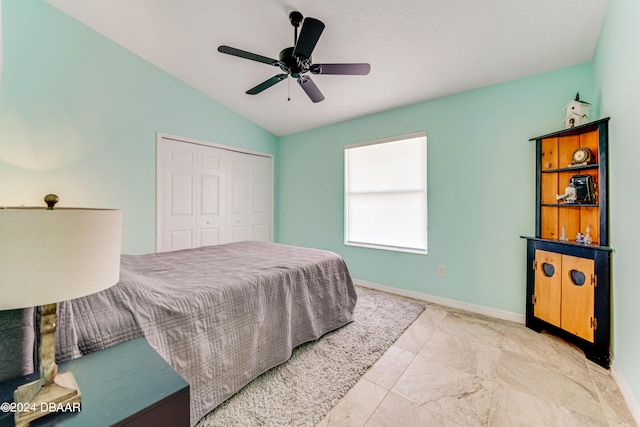 bedroom featuring ceiling fan, a closet, and lofted ceiling