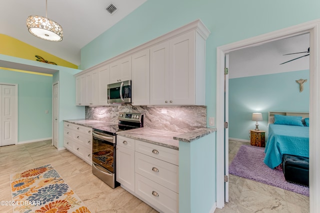 kitchen with vaulted ceiling, white cabinets, decorative backsplash, appliances with stainless steel finishes, and decorative light fixtures