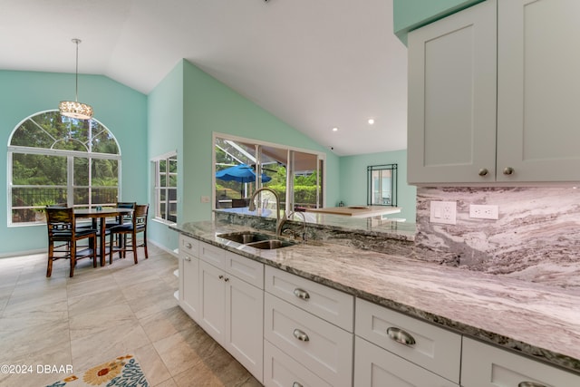 kitchen featuring white cabinetry, lofted ceiling, sink, and plenty of natural light