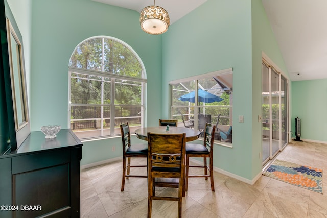 dining area featuring high vaulted ceiling and a wealth of natural light