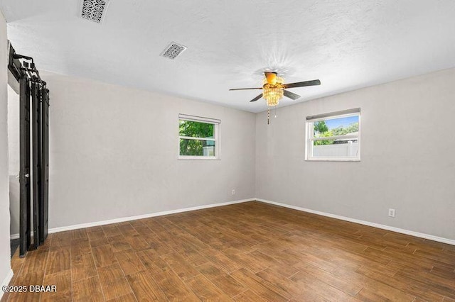 32 Twin River Dr, Ormond Beach, FL 32174 - empty room featuring a ceiling fan, visible vents, a healthy amount of sunlight, and wood finished floors