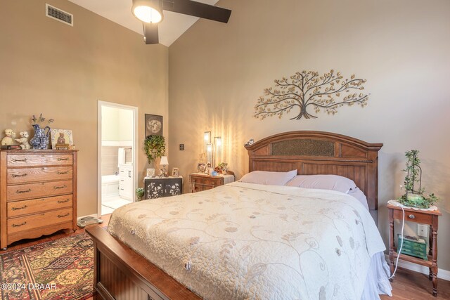 bedroom with ensuite bathroom, ceiling fan, dark hardwood / wood-style floors, and high vaulted ceiling