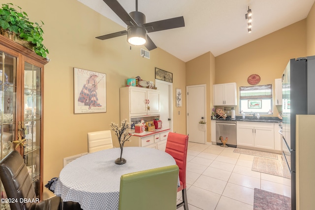 tiled dining room with ceiling fan, sink, and high vaulted ceiling