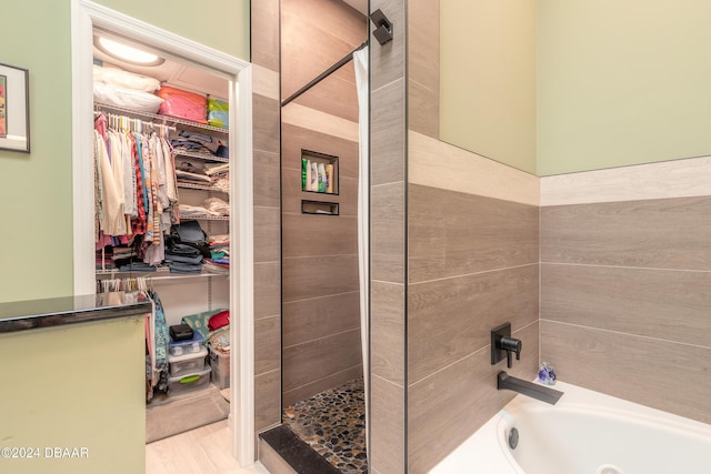 3836 Long Grove Ln, Port Orange, FL 32129 - bathroom featuring a stall shower, a walk in closet, and a tub with jets