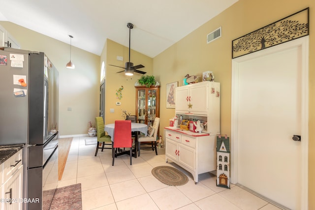 kitchen featuring ceiling fan, white cabinetry, light tile patterned floors, and stainless steel refrigerator