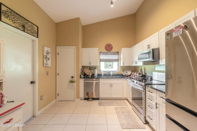 kitchen featuring white cabinets, light tile patterned flooring, sink, and appliances with stainless steel finishes