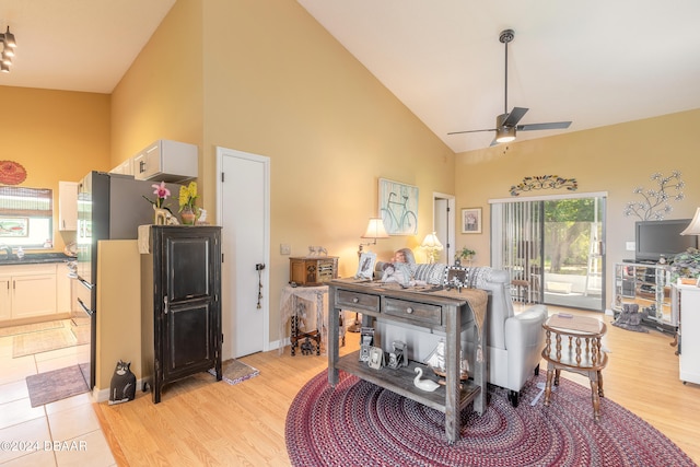 living room featuring ceiling fan, light wood-type flooring, and high vaulted ceiling