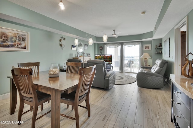 dining room featuring ceiling fan, light wood-type flooring, and baseboards